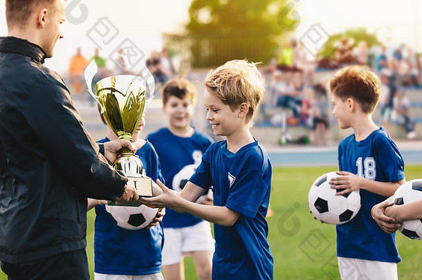 快乐微笑的年轻男孩庆祝体育足球锦标赛。赢得青年足球锦标赛的球队。体育背景。青年足球运动员