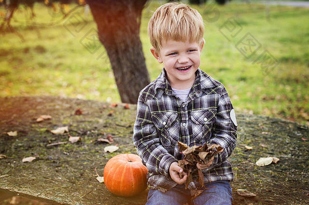 美丽的休闲金发碧眼的孩子坐着户外表格笑秋天户外肖像