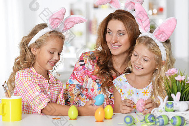 母亲和女儿们画复活节彩蛋