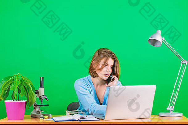 秘书在工作场所使用手机。女人在办公室里用笔记本电脑工作。桌子上拿着显微镜的女人。女商人在打电话。数据和信息。商务沟通。核对号码。