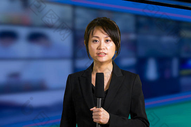 以屏幕为背景的亚裔美国女新闻主播