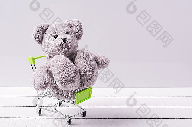 小购物车和一只泰迪熊。出售玩具或儿童幻想的概念形象