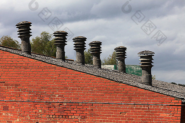 旧工厂，屋顶线上方可见石棉烟囱/烟道，石棉屋顶和红砖墙，工程非常昂贵