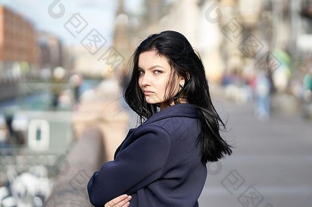 这幅肖像画描绘了一位美丽、聪明的黑发女郎，她走在市中心圣彼得堡的大街上。迷人体贴的女人，留着黑色长发