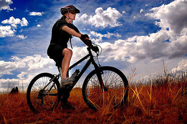 在小径上骑山地自行车的年轻女子