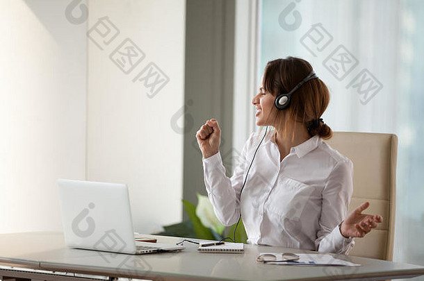 兴奋的女员工在办公室听最喜欢的歌曲