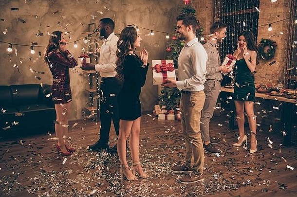 圣诞派对x-mas之夜，帅哥在家里给情人送包裹，五彩纸屑掉在地板上的全尺寸侧面照