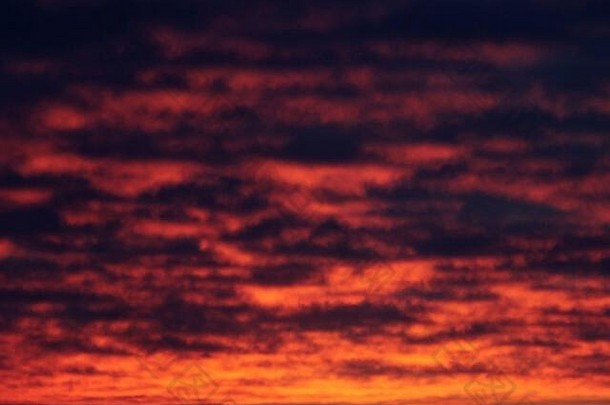 日落或黄昏日出时被太阳照亮的深红色天空。