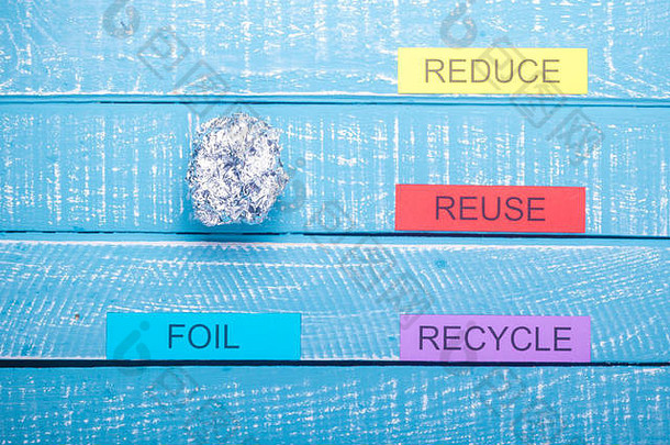 回收概念，在蓝色风化背景上显示减少、再利用和回收箔