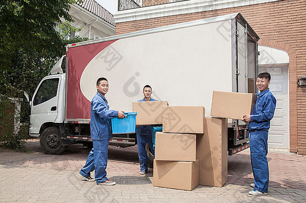 搬运工卸下一辆移动的货车，许多堆叠的纸板箱