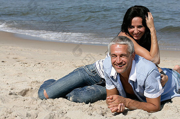 快乐的中年夫妇在海滩上休息，一起享受暑假。