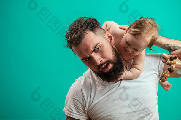 顽皮的父亲在蓝色背景上脖子上抱着微笑的婴儿