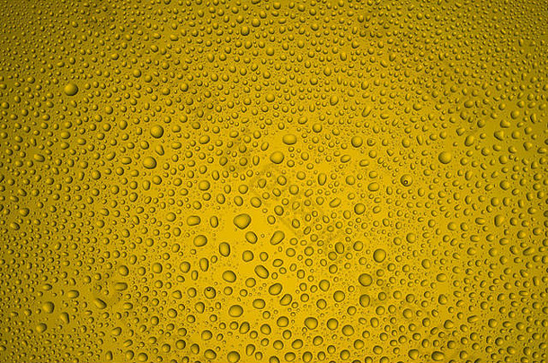黄色玻璃上不同大小水滴的背景