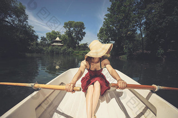 年轻的女人划船船夏天一天