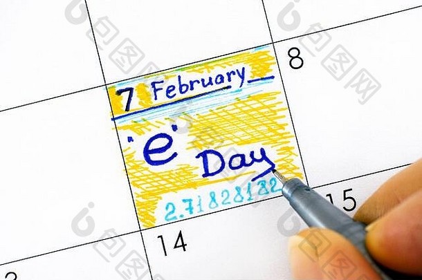 女人用手指在日历上用钢笔书写提醒。E日在2月7日庆祝（2/7）