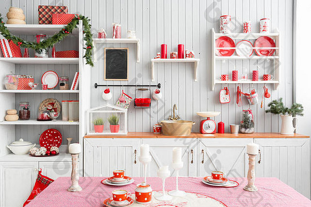 室内浅灰色厨房和红色圣诞装饰。在家准备午餐的厨房概念。