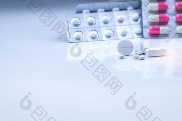 白色片剂-模糊的白色粉红色胶囊和泡罩包装的圆形片剂。药店产品。制药业。保健