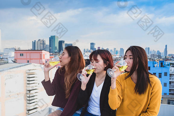 一群快乐的亚洲女朋友在屋顶派对、节日庆典、青少年生活方式、自由活动中享受欢笑和欢快的起泡酒杯