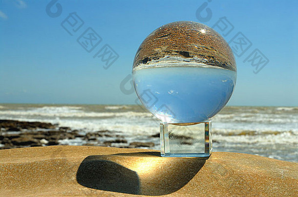 海滩上的玻璃球、水晶球、海浪、岩石、海天