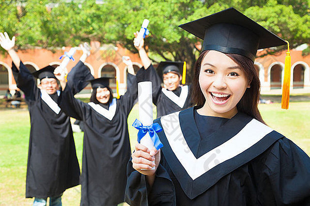 快乐的大学毕业生在校园里和朋友们一起拿着文凭