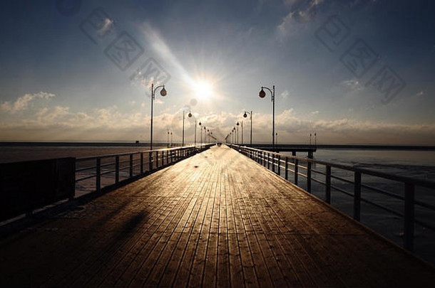 日落时分，在波兰朱拉塔的波罗的海，提着<strong>灯笼</strong>沿着木制码头散步