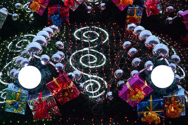 片段巨大的圣诞节树饰品礼物盒子发光的<strong>灯</strong>照片装饰圣诞节树特写镜头