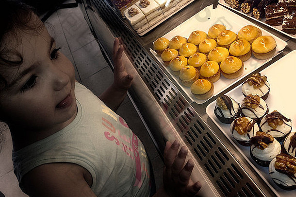 一个拉丁甜食女孩在糕点店看起来很甜美