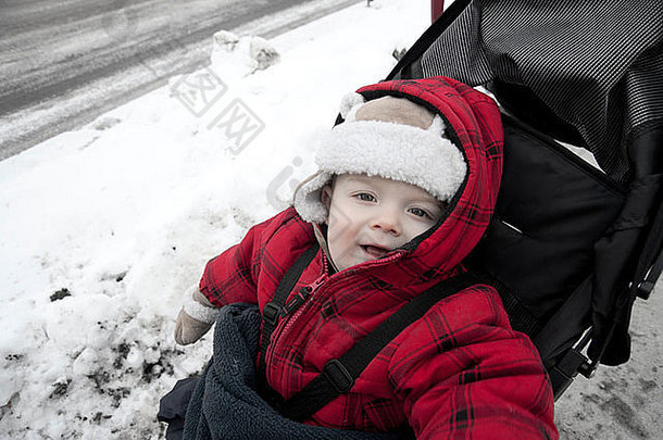 冬天婴儿车里的婴儿对着镜头微笑