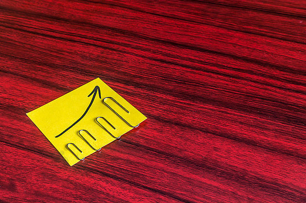回形针按大小贴在黄色便笺上，上面写着箭头。