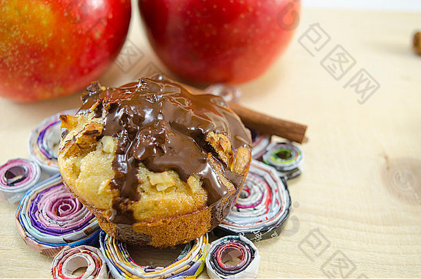 美味的巧克力松饼站手使纸板苹果背景