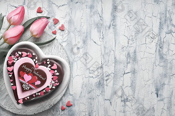 情人节心形蛋糕，巧克力，糖装饰，文字快乐Valeitine和一束粉红色郁金香。带有copy-s的浅背景俯视图