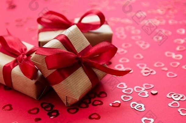 爱情，情人节背景。用牛皮纸包装的礼品盒，红色背景上隔离的红结。