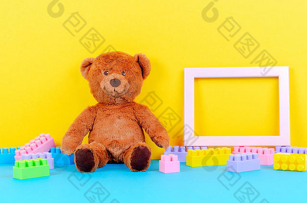 婴儿玩具背景为空画框、泰迪熊和彩色积木