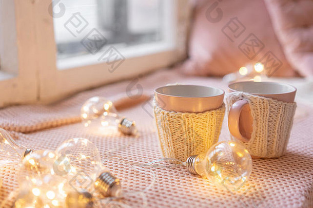 木制桌子上的编织羊毛杯。两杯热咖啡。热的概念。节日和活动。秋冬，休闲理念。舒适的，舒适的，柔软的。