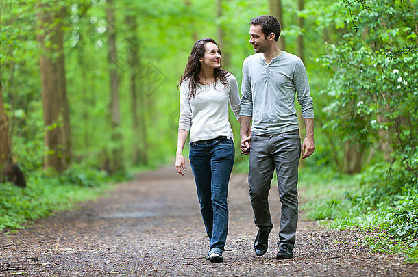 一对年轻夫妇在森林里散步的情景