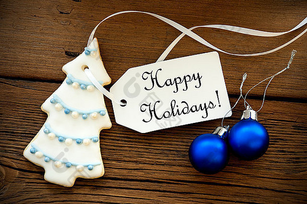 圣诞树饼干和蓝色圣诞球，上面有一个标签，上面写着节日快乐、圣诞节或寒假问候语