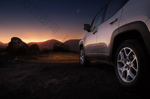 日落时沙漠道路上汽车的特写镜头和复印空间