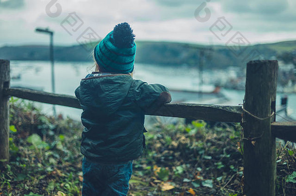 一个蹒跚学步的小孩正在欣赏海滨小镇的景色
