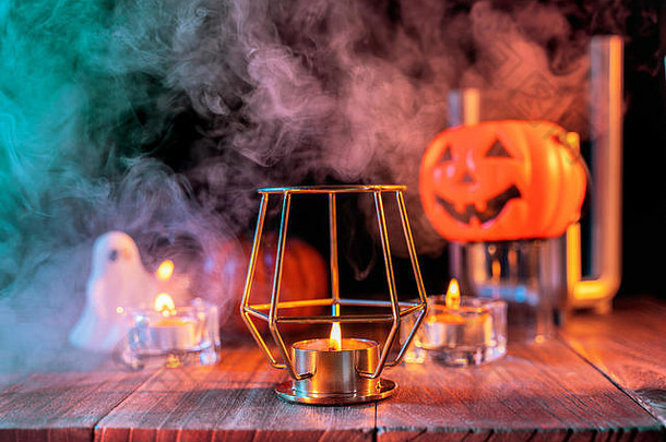 万圣节的概念，橙色的南瓜灯和蜡烛放在一张深色的木桌上，<strong>背景</strong>是绿色的橙色烟<strong>雾</strong>，不给糖就捣蛋，特写镜头