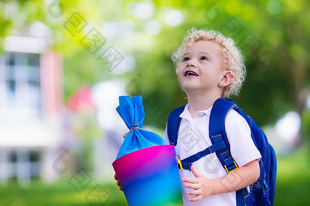 开学第一天，快乐的孩子拿着传统的德国糖果筒。拿着书的小学生很兴奋能回到学校。