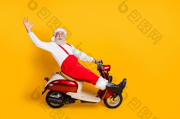 有趣的圣诞老人白发祖父骑自行车赶新年x-mas主题派对打招呼的全长照片穿裤子帽子吊带衬衫