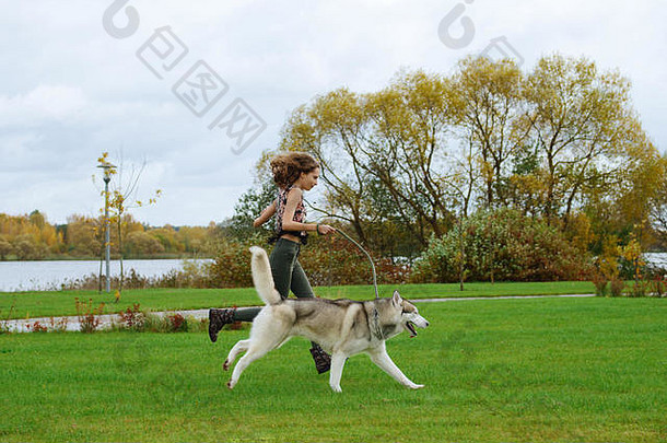 女孩玩沙哑的狗城市公园慢跑狗