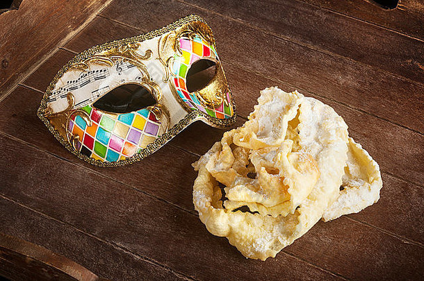 意大利狂欢节的典型油炸糕点，带威尼斯面具。这些甜食有不同的名称，如chiacchiere、Galani cenci