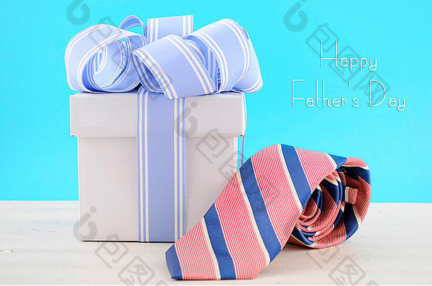 父亲节快乐礼物，蓝色和白色丝带，红色和蓝色条纹领结，白色木桌，浅水蓝色背景