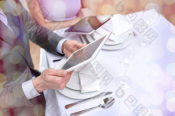 一对夫妇在餐厅使用平板电脑的特写镜头