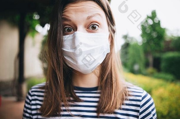 一名金发女孩在郊外戴着医用防护面具，头顶被剥光