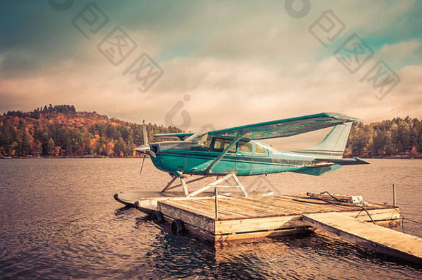 水上飞机停靠在纽约州长湖的岸边，等待着观叶者和<strong>冒险者</strong>，复古的分裂色调