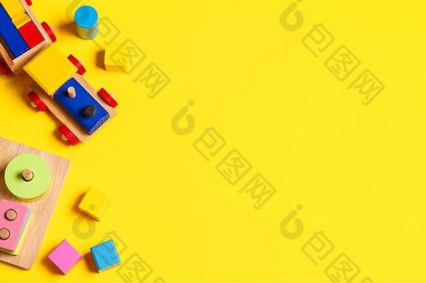 婴儿<strong>玩具</strong>背景。木制火车，教育堆叠颜色识别<strong>益智玩具</strong>和黄色背景上的彩色积木。俯视图