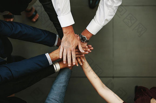 <strong>团结协作</strong>的理念。商务人士把手放在一起的俯视图。