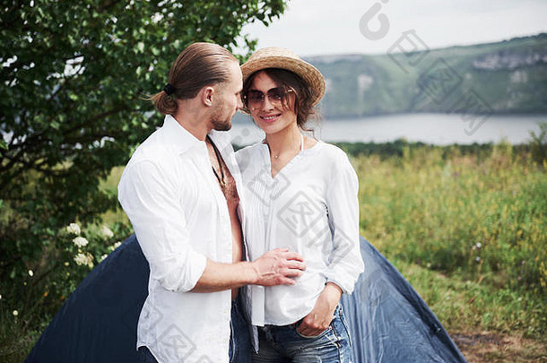年轻人的画像，一男一女，游客们站在帐篷附近，<strong>发现自己</strong>在大自然中休息